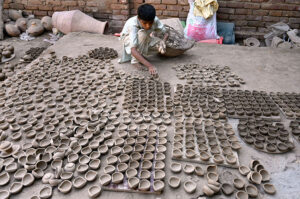 An artisan busy preparing traditional clay-made oil lamp for use upcoming Hindu festival Dewali at his workplace in kumharpara
