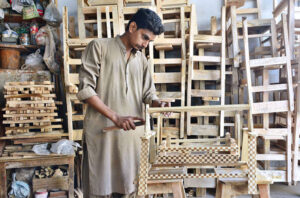 A carpenter busy making wooden toys at his workplace.
