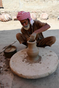 Craftsmen busy in preparing clay made pitchers at their workplace at Kumharpara