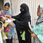 Polio worker administering polio drops to children at Sodiwal during anti-polio vaccination campaign in Provincial Capital