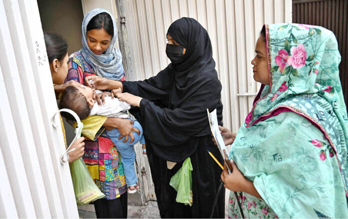 Polio worker administering polio drops to children at Sodiwal during anti-polio vaccination campaign in Provincial Capital