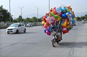 Street vendor on the way loaded balloons on his motorcycle in search of customers in the federal capital.