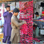 Vendors are busy preparing flower garlands at their roadside setup
