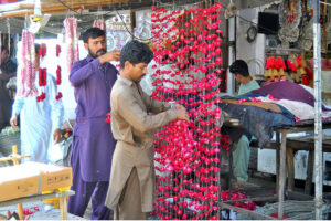 Vendors are busy preparing flower garlands at their roadside setup