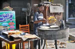 Vendor is busy preparing parathas for the customers at his roadside setup