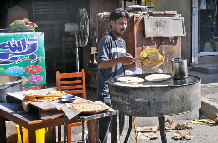 Vendor is busy preparing parathas for the customers at his roadside setup