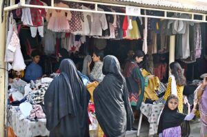 Women browse and purchase second-hand warm clothes at the weekly bazaar in Aabpara, Federal Capital, getting ready for the colder season