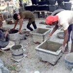 Workers preparing cement-sand blankets at their work site in Shahdara