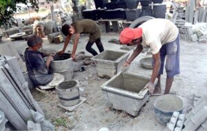 Workers preparing cement-sand blankets at their work site in Shahdara