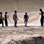 Youngsters busy in catching fishes in Rice Canal
