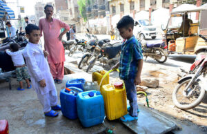 Children diligently fill their pots with clean water from a pipeline along Cloth Market Road.