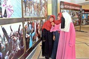 Female visitors are keenly viewing pictures exhibition of Kashmir Black Day at the Arts Council