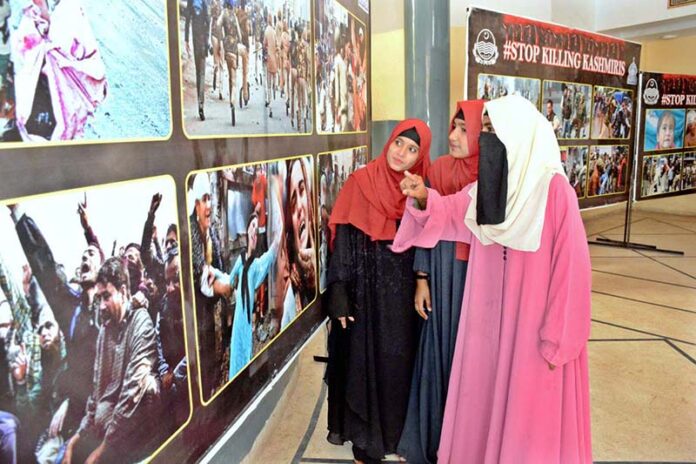 Female visitors are keenly viewing pictures exhibition of Kashmir Black Day at the Arts Council