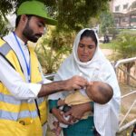 A polio health worker administers polio drops to a child at DHQ Hospetol during the anti-polio vaccination campaign