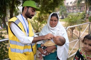 A polio health worker administers polio drops to a child at DHQ Hospetol during the anti-polio vaccination campaign