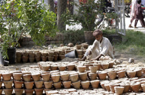 A gardener preparing flower pots at a local nursery.
