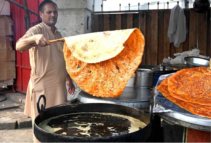 A man is preparing Qatlama on Shah Jamal Road