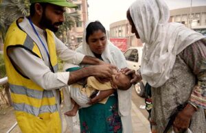 A polio health worker administers polio drops to a child at DHQ Hospetol during the anti-polio vaccination campaign