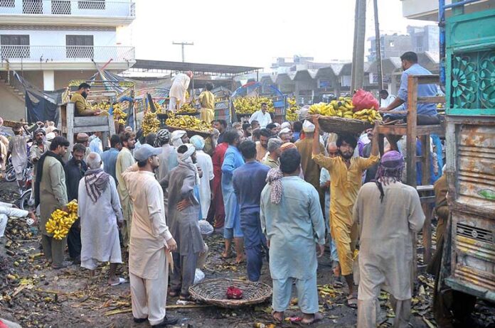 A large number of shopkeeper participating in the bidding of bananas at the Fruit Market
