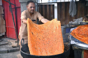 A man is preparing Qatlama on Shah Jamal Road