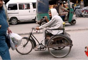 A disabled elder seeks compassion while sitting on a wheelchair from passersby at Chowk Yadgar