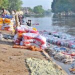A large number of labourers are busy washing empty plastic bags in the canal