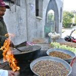 A vendor busy roasting grams for customers at Peshawar Mor