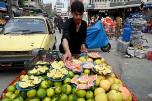 Vendor displaying and selling cutting fresh sweet lime and grapefruit to attract buyers at Namak Mandi road