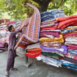 A worker busy displaying quilts for customers at his workplace in the Federal Capital