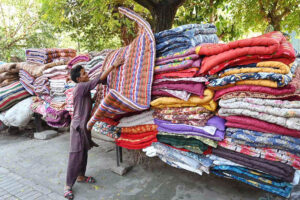 A worker busy displaying quilts for customers at his workplace in the Federal Capital
