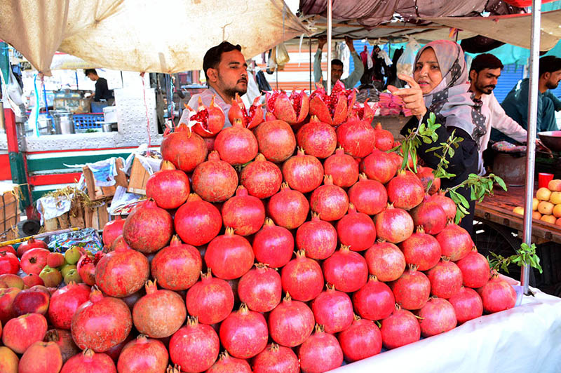 A Woman Selects and Purchases Pomegranates from a Vendor at Fakir Ka Pir Road