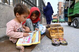 A young shoe polish girl balances study and work, teaching her brother while earning at Chowk Yadgar
