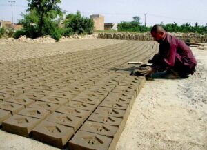 A worker making bricks at a kiln to earn for livelihood