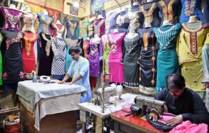 Workers busy in embroidery work on ladies wear at his workplace.