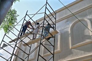 Workers painting a building in the federal capital.