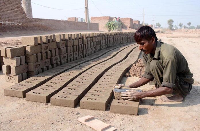 A laborer making raw bricks at a local kiln, showcasing the hard work behind construction