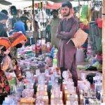 Women selecting and purchasing water glass from vendor at the Sunday Market