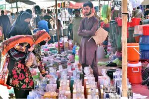 Women selecting and purchasing water glass from vendor at the Sunday Market