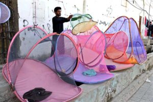 A vendor displaying nets to protect from mosquitoes bite to attract the customers at Jinnah Bagh Road