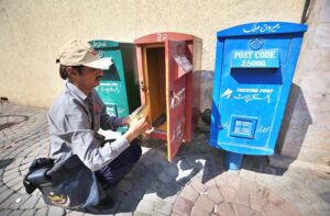 A postman is collecting letters from a post box at GPO Cantt for further delivery as world celebrates World Post Day on 9th October.