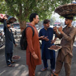 A street vendor sells dates on Mall Road, offering fresh date to passersby amidst the city