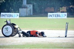 A fielder falls while attempting to catch the ball during the wheelchair cricket match between Balochistan and Sindh teams at the Interloop Quaid-e-Azam T-20 Cup Wheelchair Cricket 2024 at Bohran Wali Ground