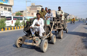 Workers transport concrete mixer machine on a vehicle for construction work on the roads in the city.