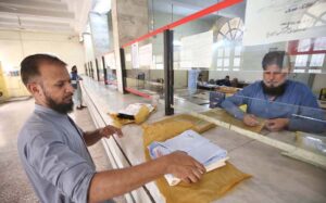 A postman is collecting letters from a post box at GPO Cantt for further delivery as world celebrates World Post Day on 9th October.