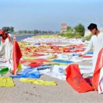 Labourers are busy spreading plastic bags for drying purpose after washing at the roadside