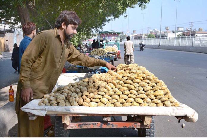 Vendors displaying sweet item (gur) to attract customers at General Bus Stand Road
