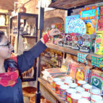 A Women browses and selects handcrafted decorative items especially truck art at a handicrafts shop near Delhi Gate