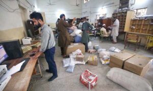 A postman is collecting letters from a post box at GPO Cantt for further delivery as world celebrates World Post Day on 9th October.
