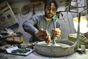Laborer busy in polishing stone decoration pieces at his workplace near Sarafa Bazaar.