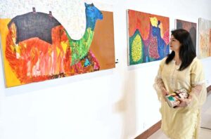 An art enthusiast keenly observing the exhibits during the inauguration of "PASSAGES OF LIGHT," an exhibition featuring paintings by Sri Lankan artists Mueen Saheed and Bilaal Raji Saheed at the Pakistan National Council of the Arts (PNCA).